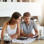 Un jeune couple analyse les frais d'assurance vie de son contrat d'épargne.