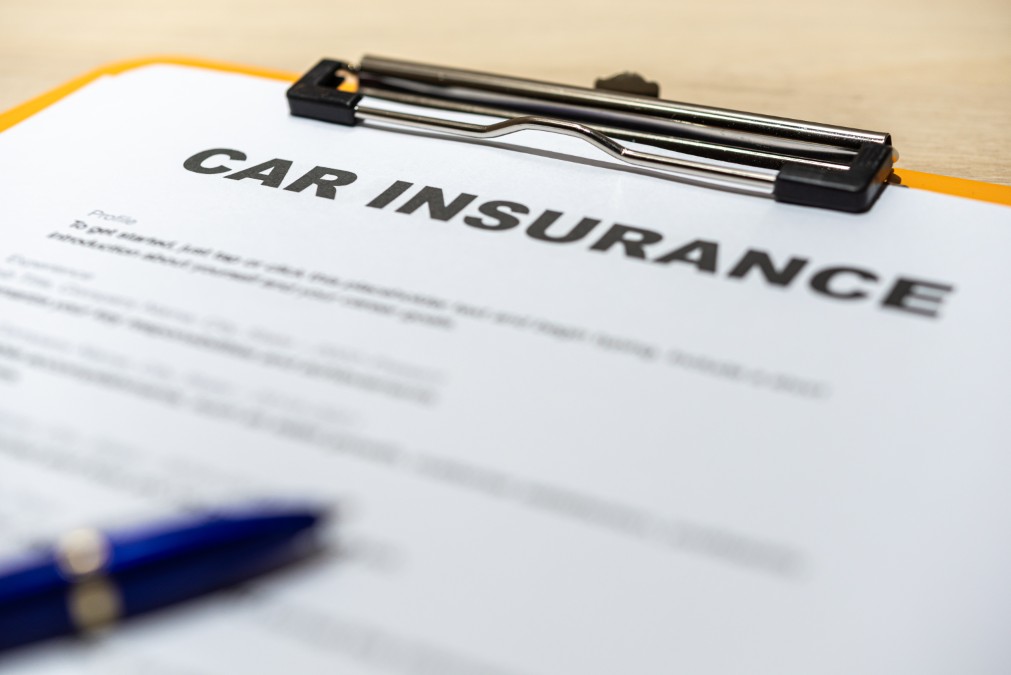 Assurance auto prêt de volant : formulaire de contrat et stylo pour déclarer un conducteur occasionnel