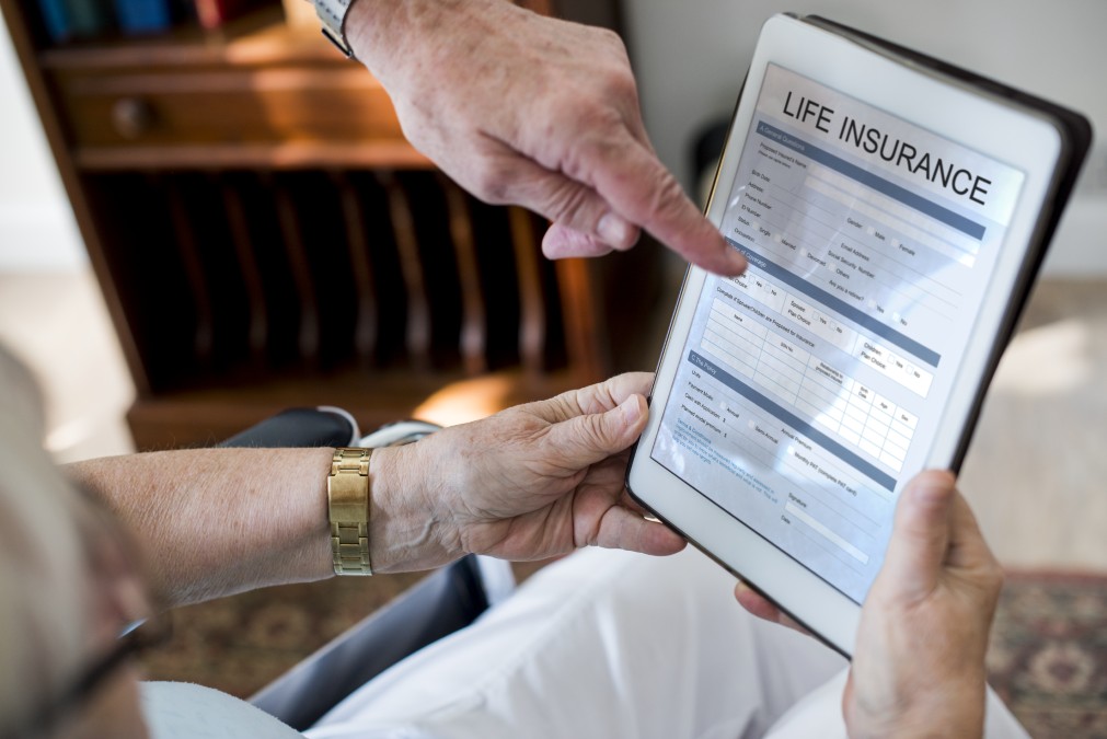 Un homme consultant les garanties d'un contrat d'assurance vie CANMP sur une tablette